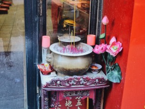 Burning incense outside a Buddhist temple on Broome St.